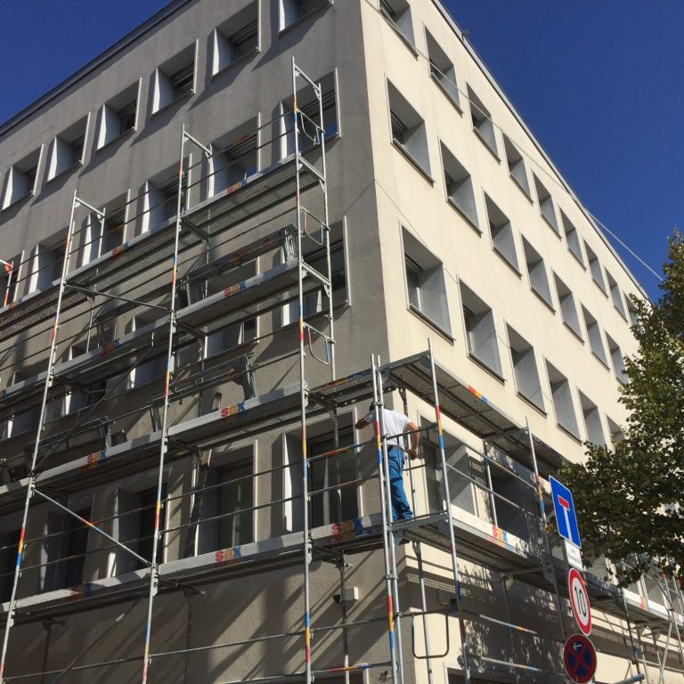 Moderne Badezimmer mit grauen Wänden, Regenduschkopf und Handtuchhalter.